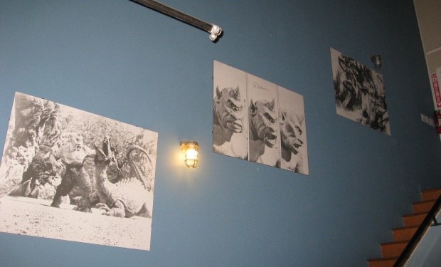 A series of signed Ray Harryhausen film scene prints adorn an office wall.