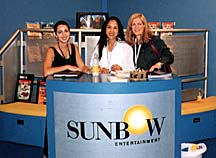 The Sunbow Entertainment booth at MIPCOM. Sunbow  staffers, from left to right: Janet Scardino, senior vice  president of International Sales & Co-Production; Bernadette  Madlangbayan, manager of Press & Marketing and  Carrie Romeo, director of Sales & Acquisitions.  Photo by Alisa Anderson.