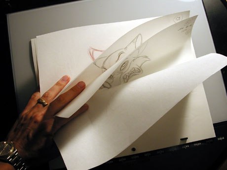image of a hand rolling through sheets of paper, animating an drawing of a fox